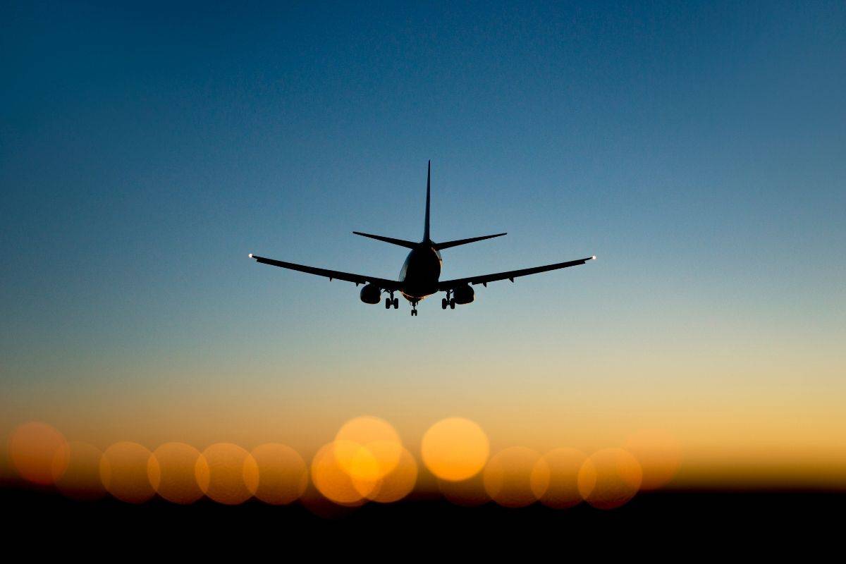 Airplane landing at sunset