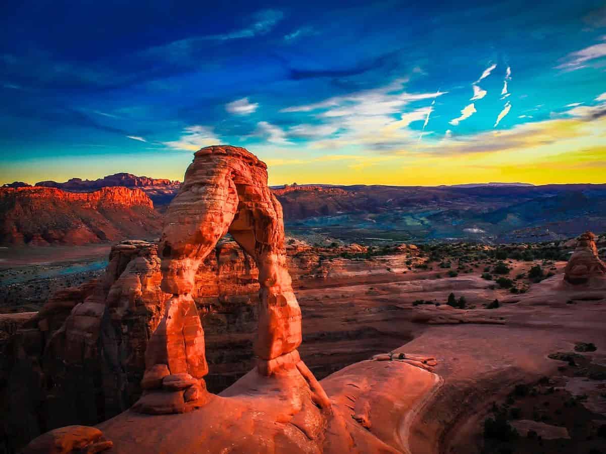 A gorgeous red rock arch at sunset in Arches National Park in Utah.