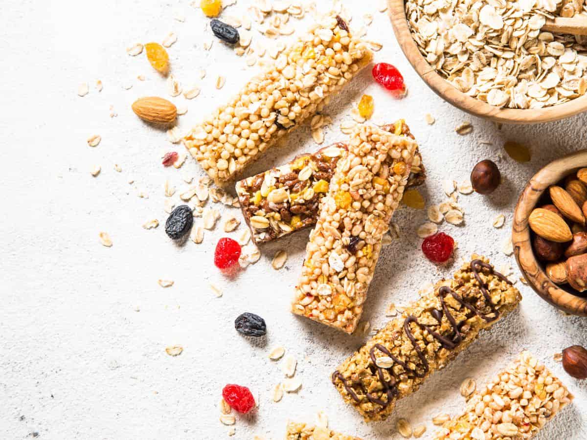 Assortment of Granola Bars Next to a Bowl of Oats and Almonds