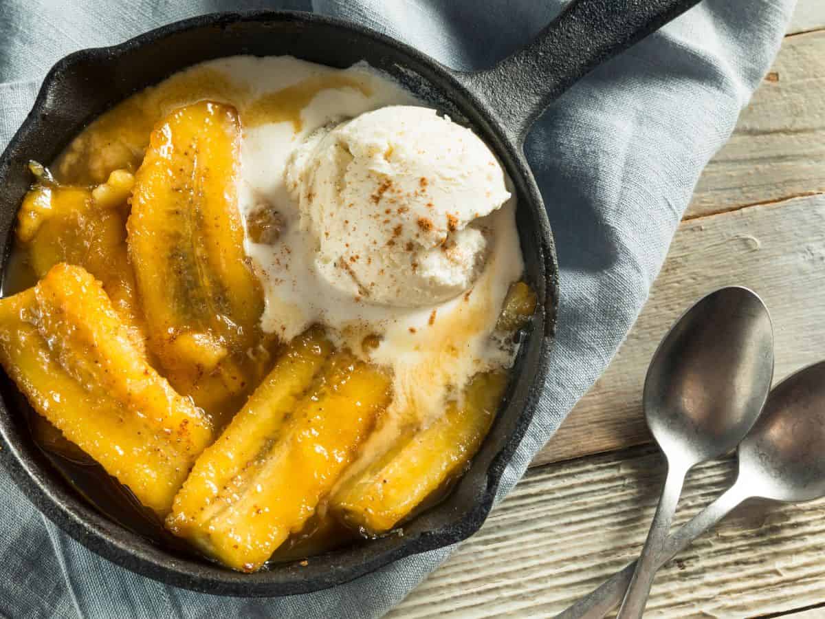 A skillet filled bananas foster and vanilla ice cream.