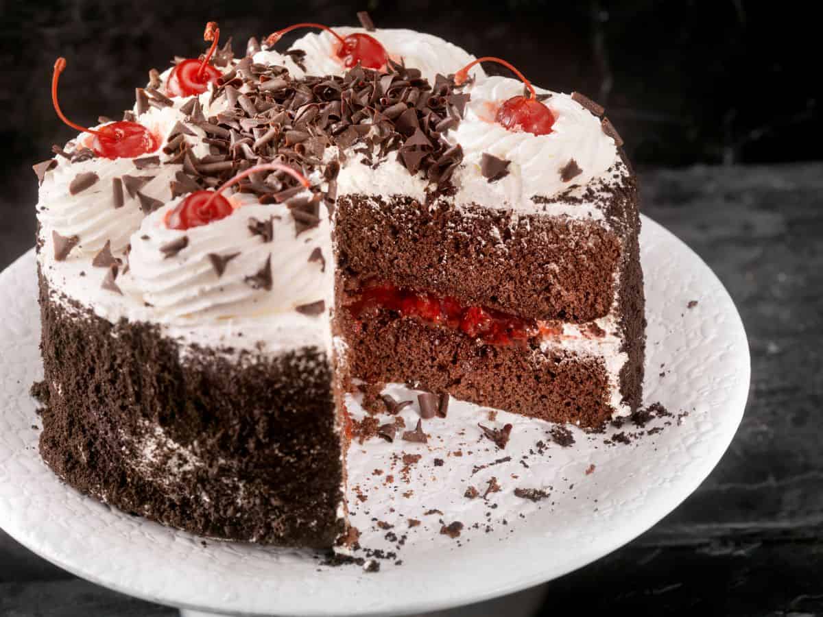 A Black Forest cake with a slice taken out of it.