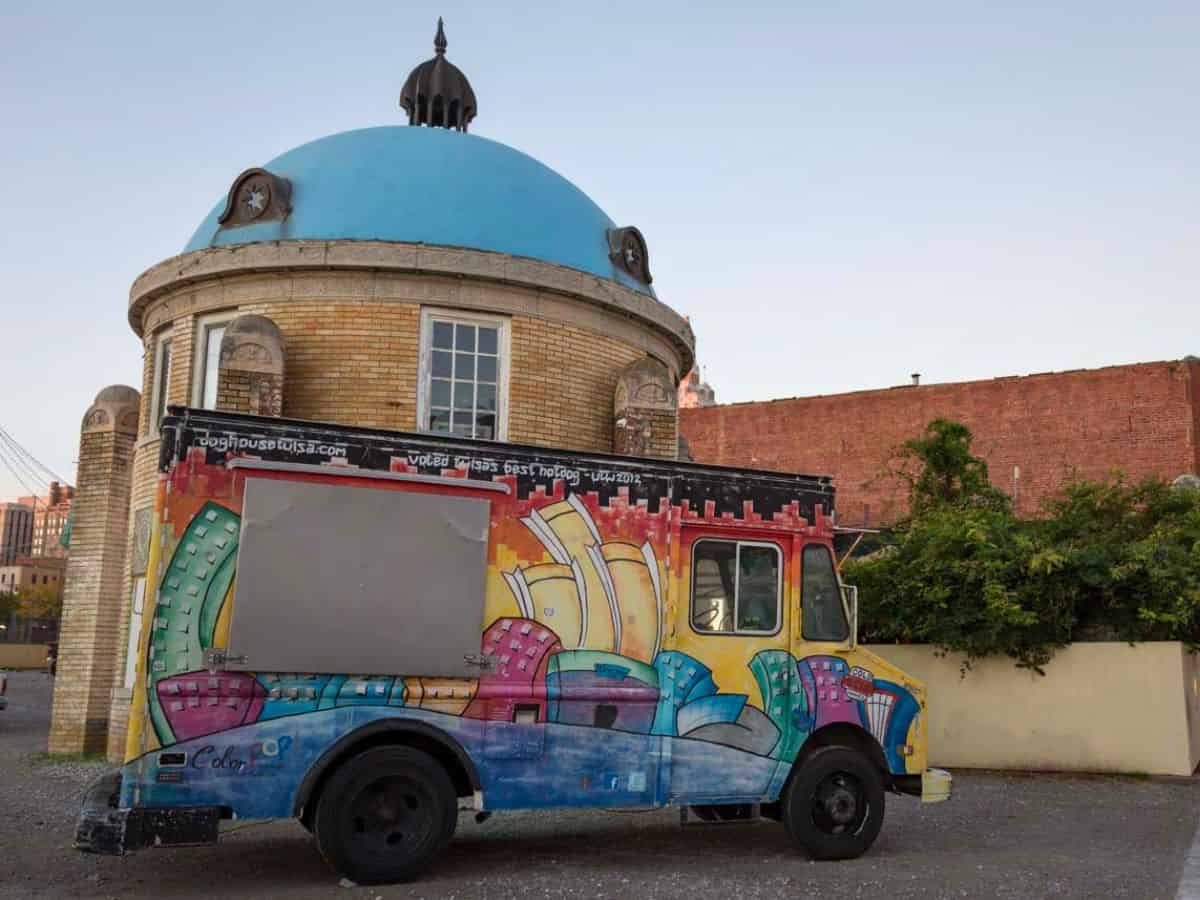 A colorful food truck parked in front of a blue-domed building in Tulsa, OK.