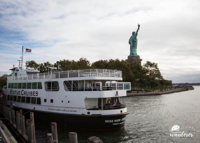 A cruise boat with the Statue of Liberty in the background