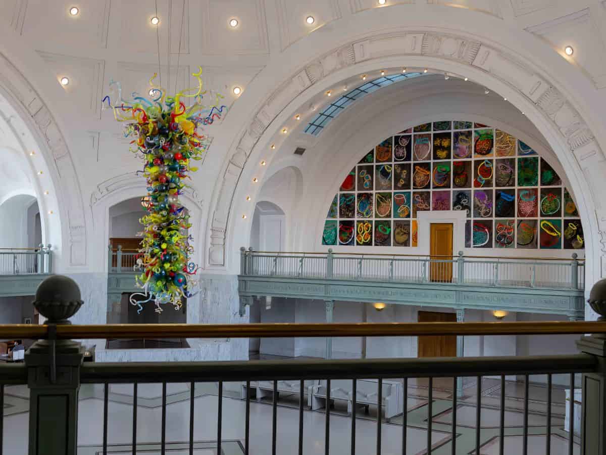 A large glass sculpture by Dale Chihuly hanging from the ceiling of a building in Tacoma.