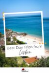 A view of a coastal area with a sandy beach, clear blue sea, and a few people sunbathing and swimming. Text on the image reads, "Best Day Trips from Lisbon.