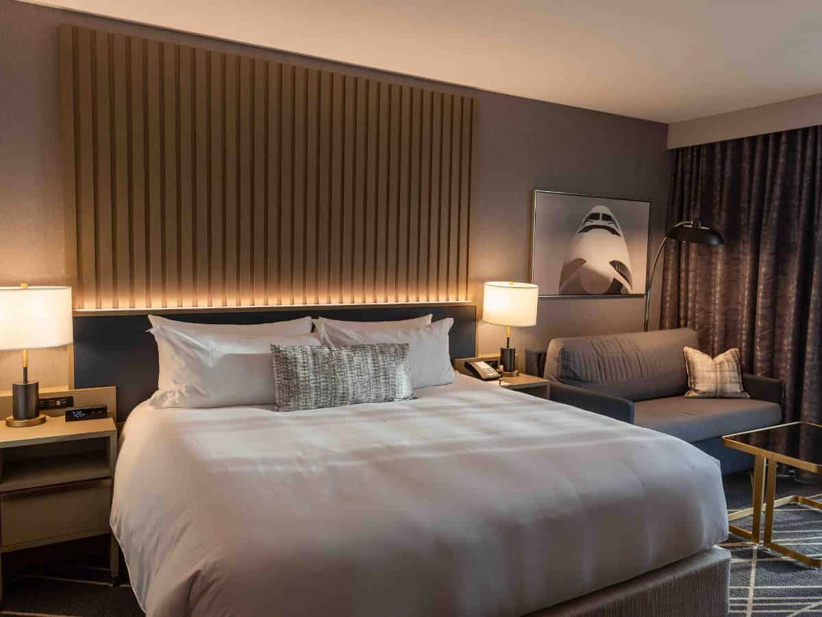 A cozy hotel room at Loews Kansas City Hotel featuring a comfortable bed and a stylish couch.