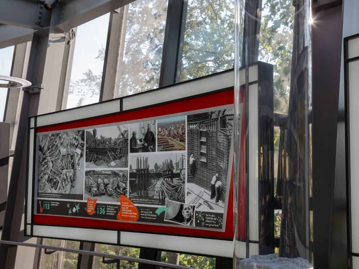 A photo exhibit lining the queue to ascend the Space Needle in a glass elevator.