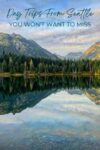 A scenic mountain landscape with a forest and lake, reflecting the sky and trees. Text reads: "Day Trips From Seattle You Won’t Want To Miss.