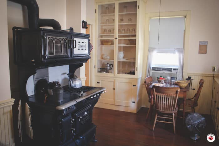 A pot of baked beans sits on an early 20th century stove.