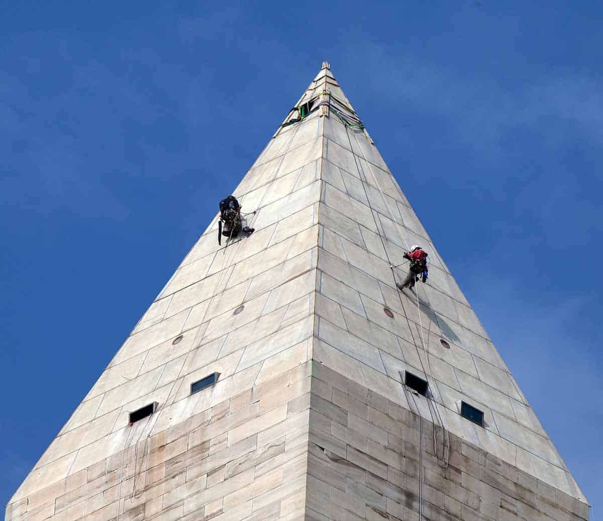 Two men are scaling the height of the Washington Monument.