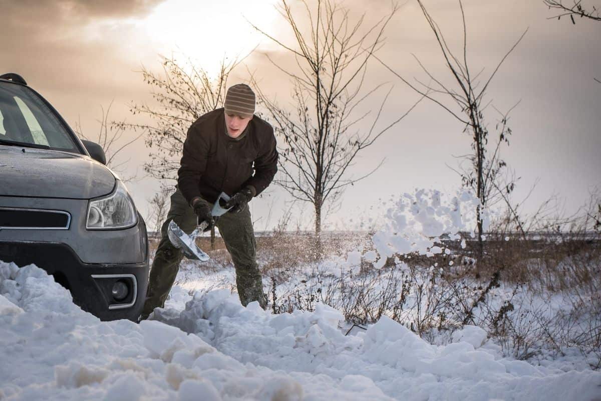 Man Digging Car Out of Snow Drift