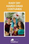 Three people wearing colorful Mardi Gras costumes and holding drinks, with a decorative plant in the background.