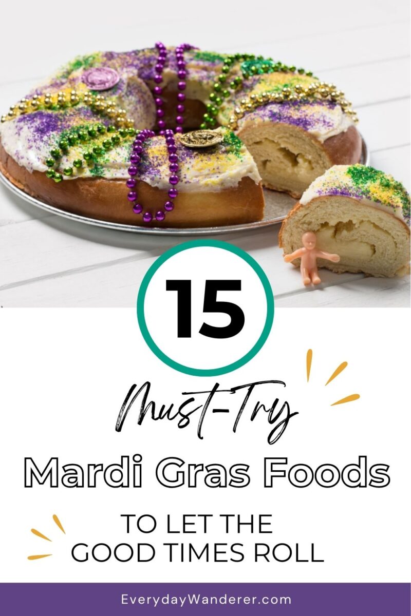King cake with colorful icing and beads on a plate, partially sliced, with a small plastic baby figurine. Text reads "15 Must-Try Mardi Gras Foods To Let The Good Times Roll.