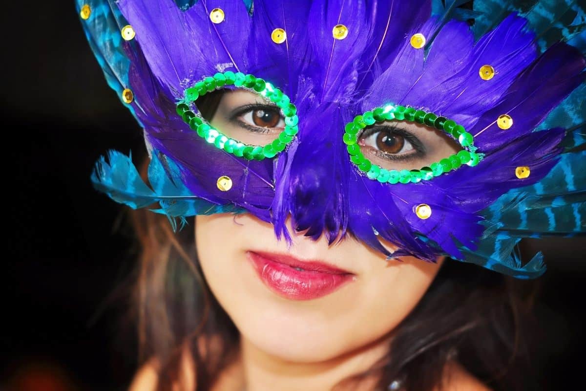 Woman in purple and green mardi gras mask