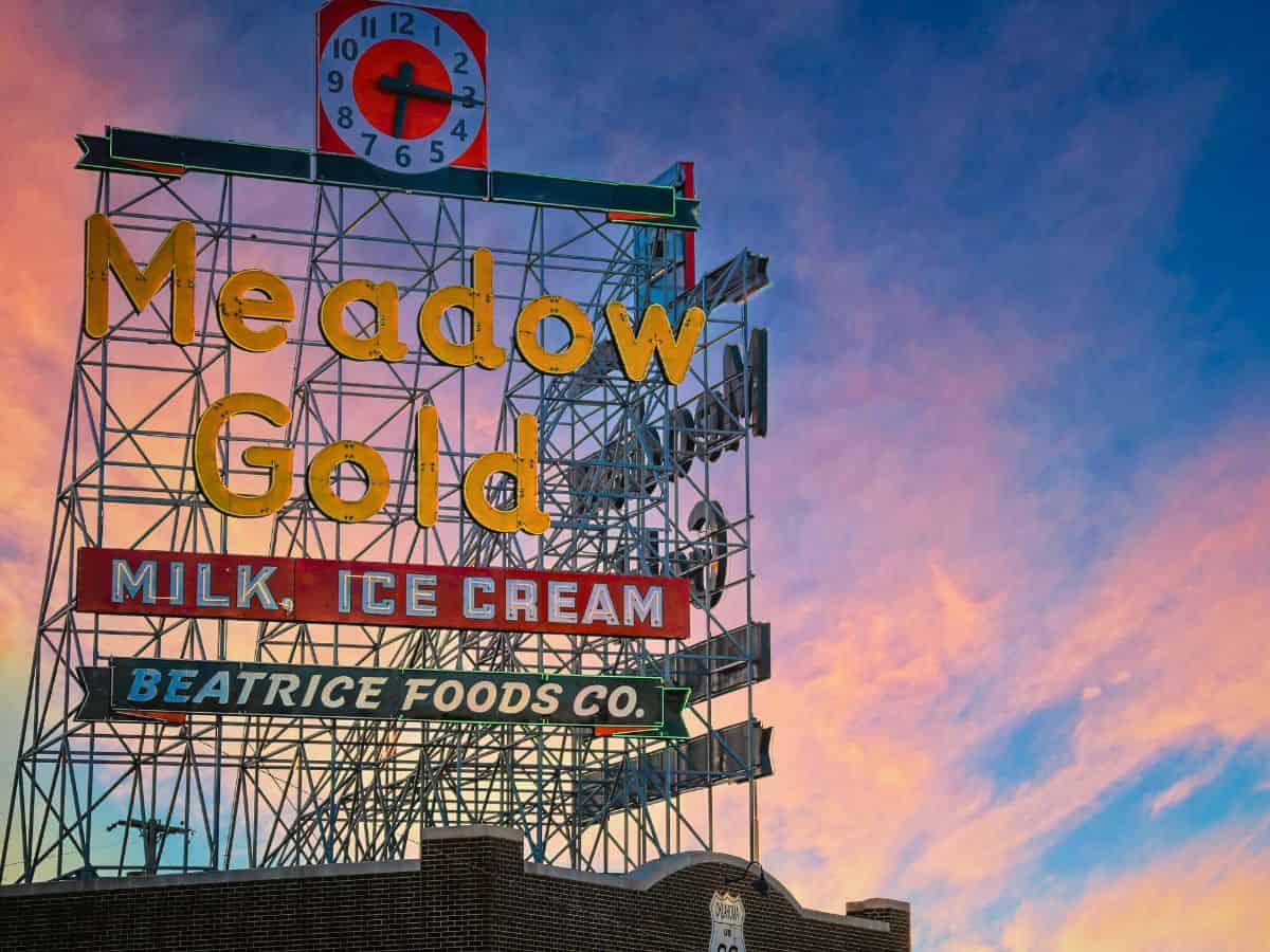 Historic Meadow Gold sign along Route 66 in Tulsa at sunset.
