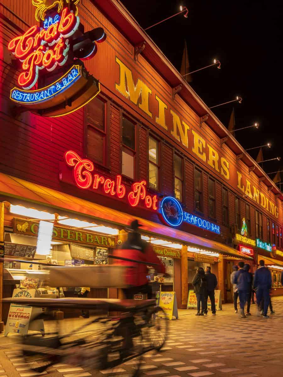 A street scene along the Seattle Waterfront at night.