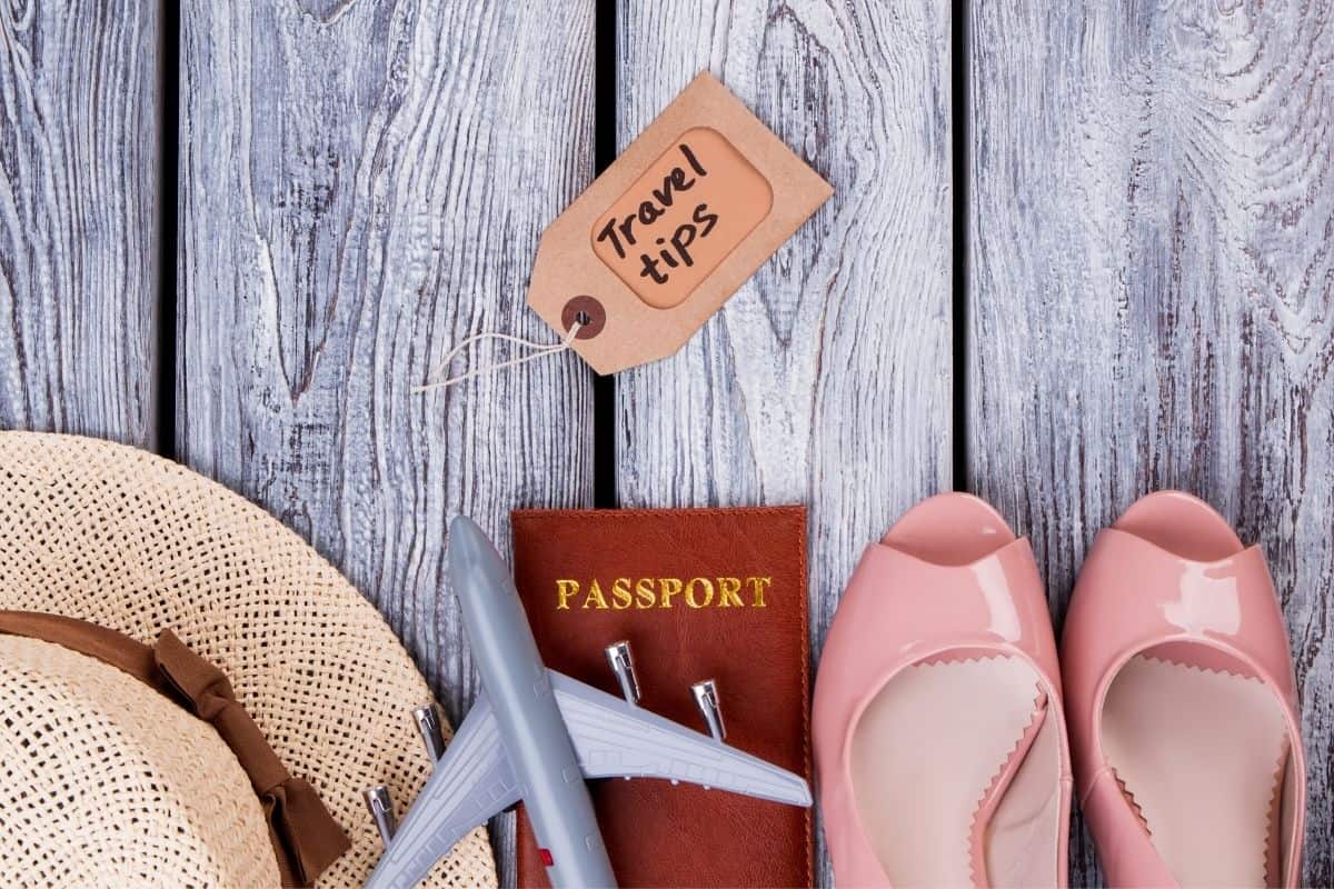 Collection of travel items including sunhat, passport, and shoes