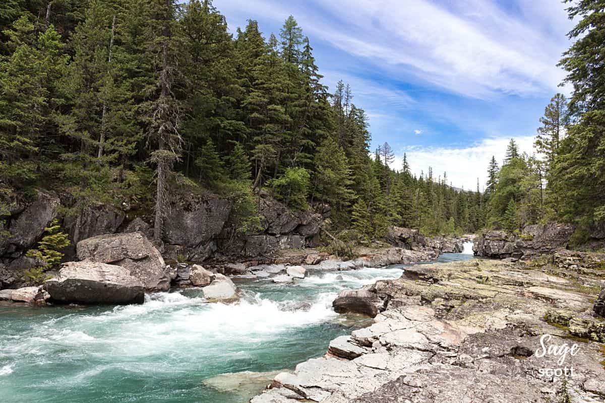 A river meandering through a landscape of rocky mountains and lush trees, showcasing the stunning natural beauty of Montana.