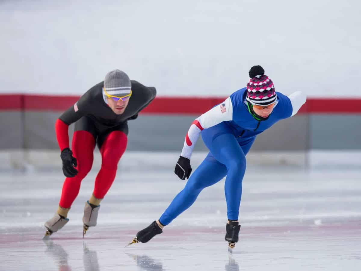 Two speed skaters racing on an ice track.