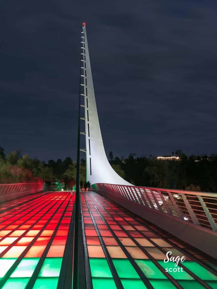 A bridge lit up at night with colorful lights.