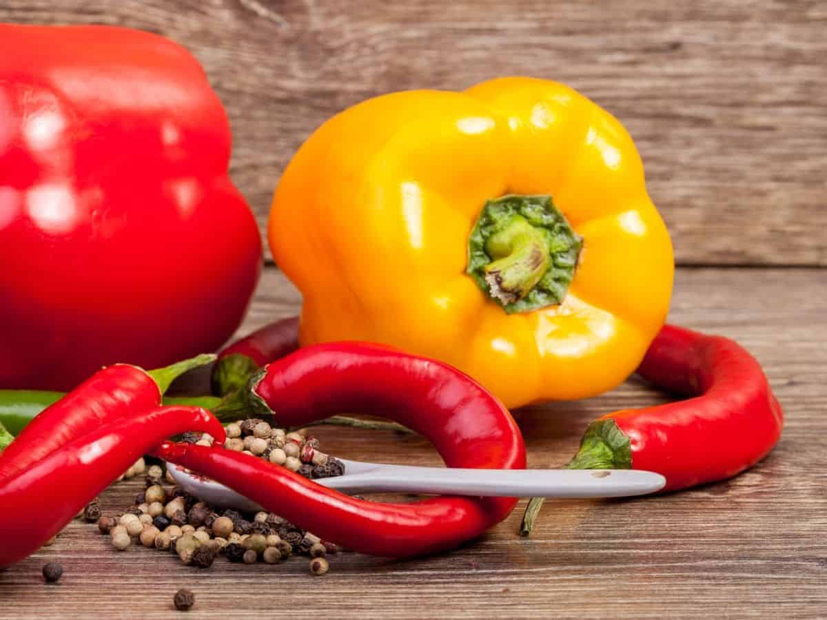 Sweet and spicy peppers on a wooden table.