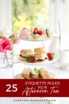 A tiered serving tray filled with an assortment of afternoon tea treats next to a window.