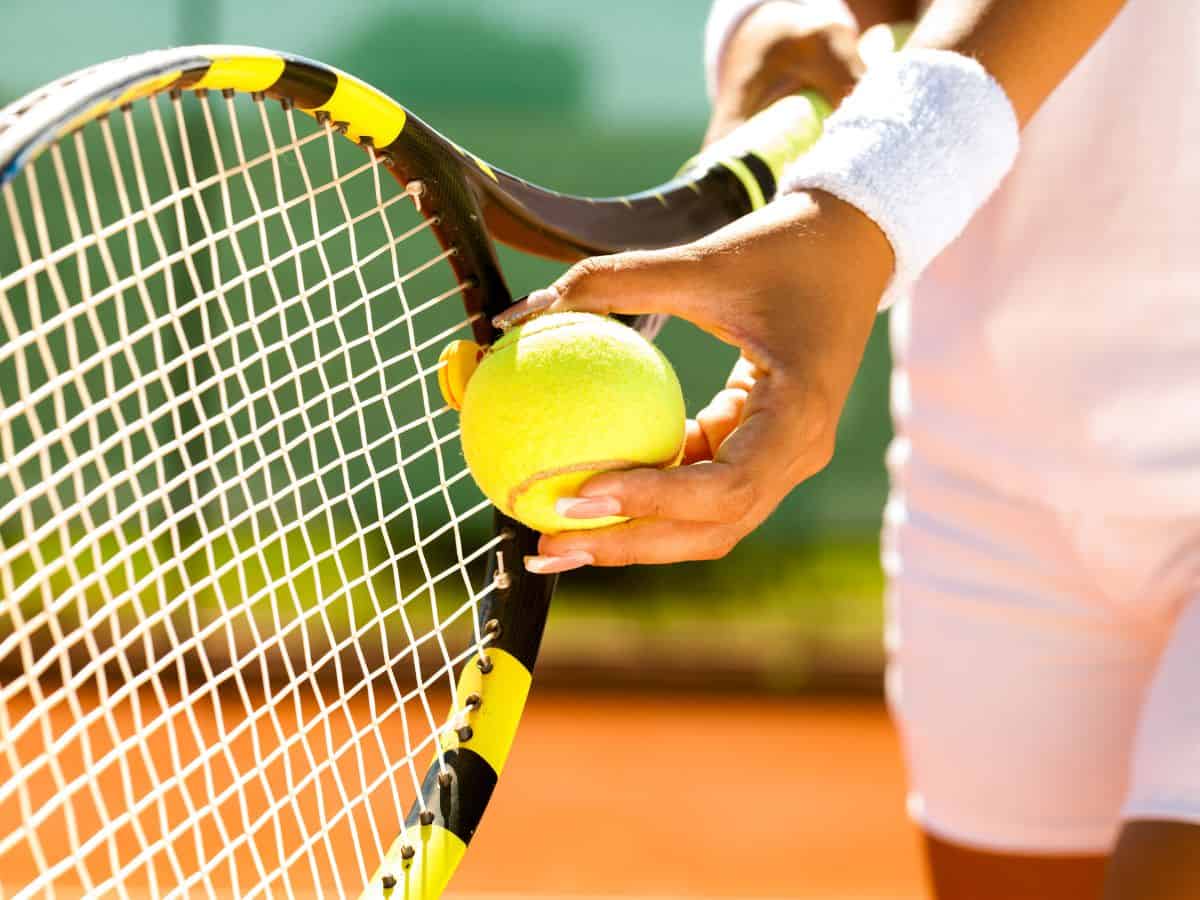 A person holding a tennis racket and tennis ball.