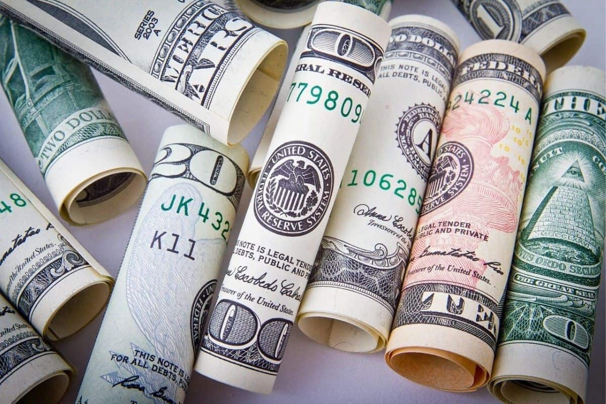 An assortment of rolled US paper bills of different denominations