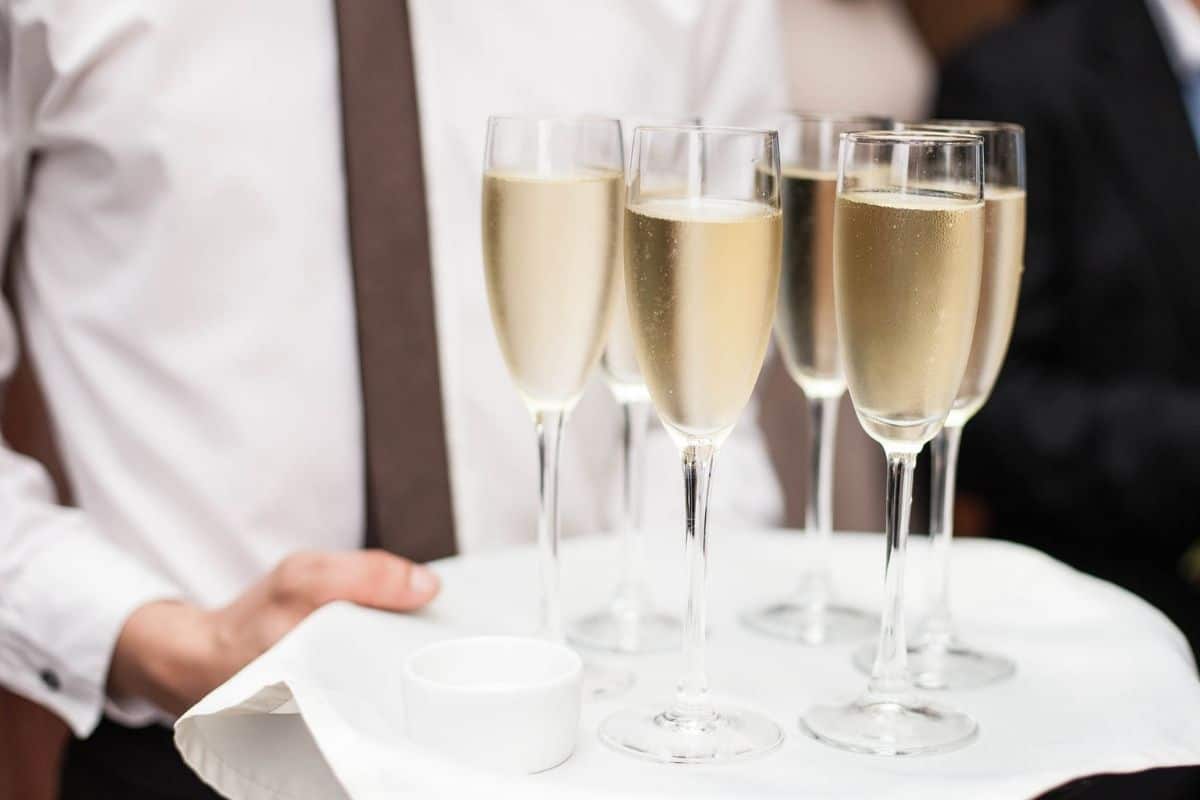 A waiter carrying a tray of wine glasses