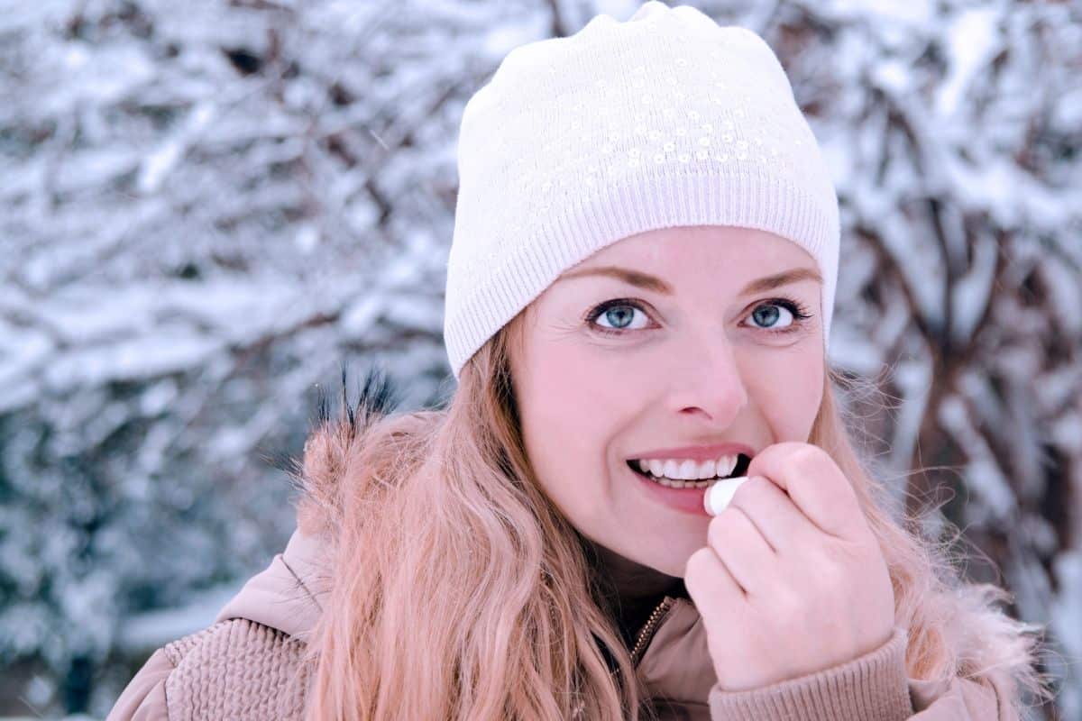 Woman Applying Chapstick in Snow
